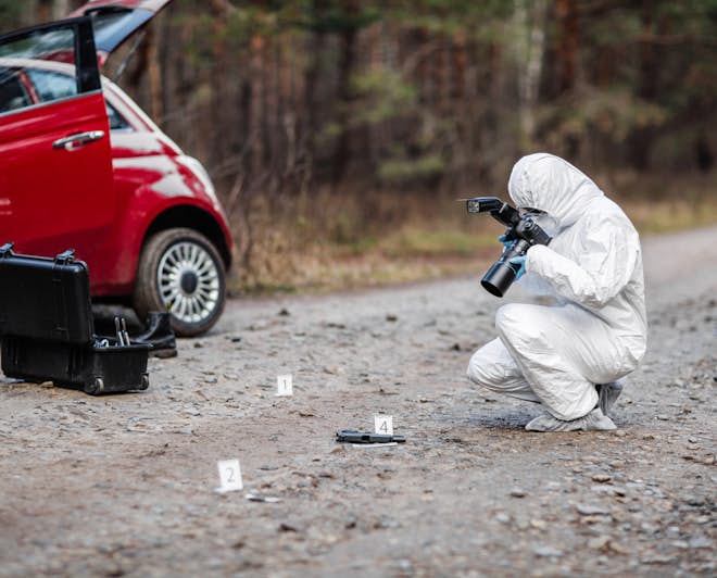 Forensic scientist taking pictures at crime scene. Study Forensic Science abroad.