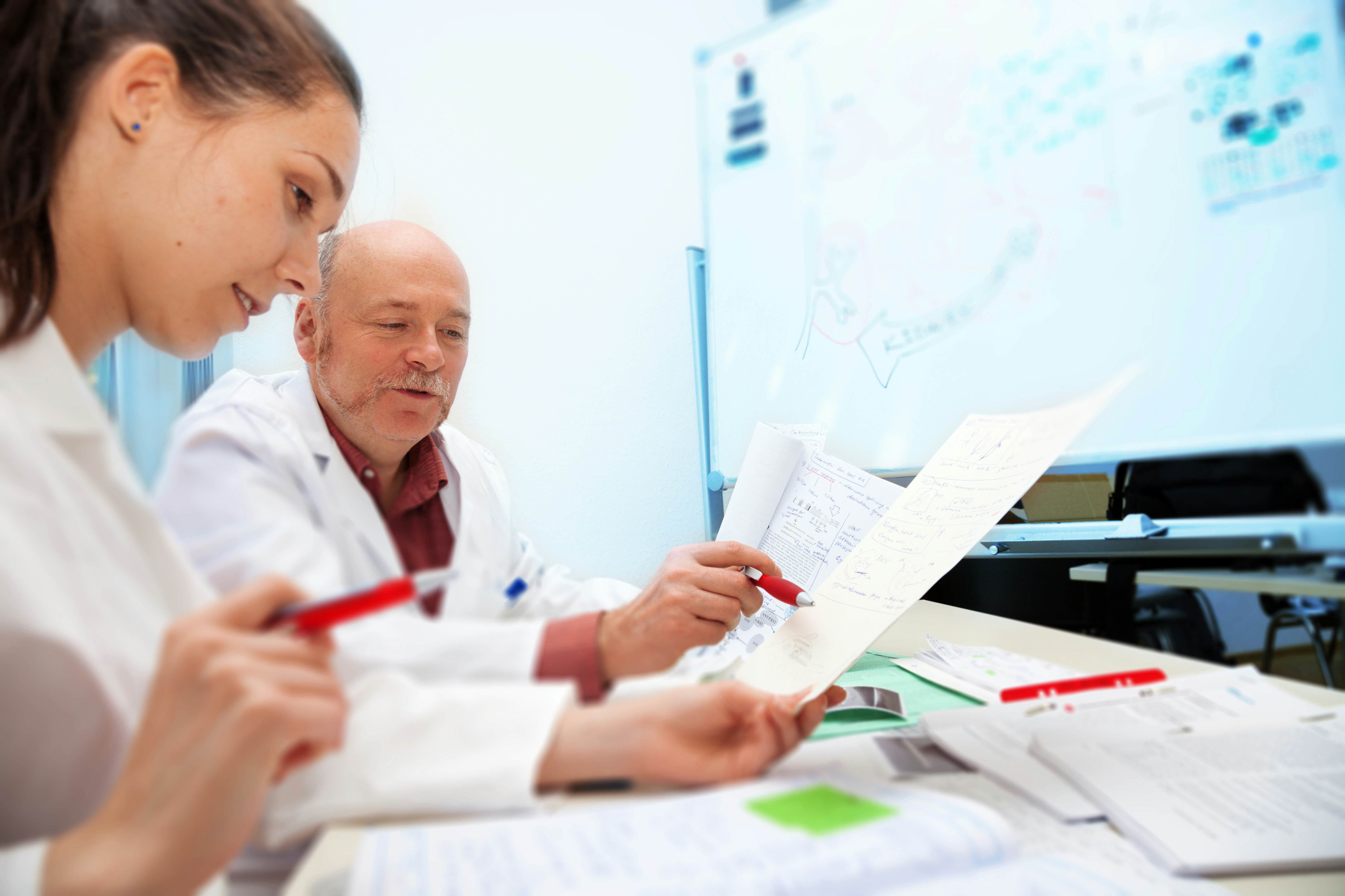 Clinical researchers examining results. Study a Master's in Public Health and become a clinical research coordinator.