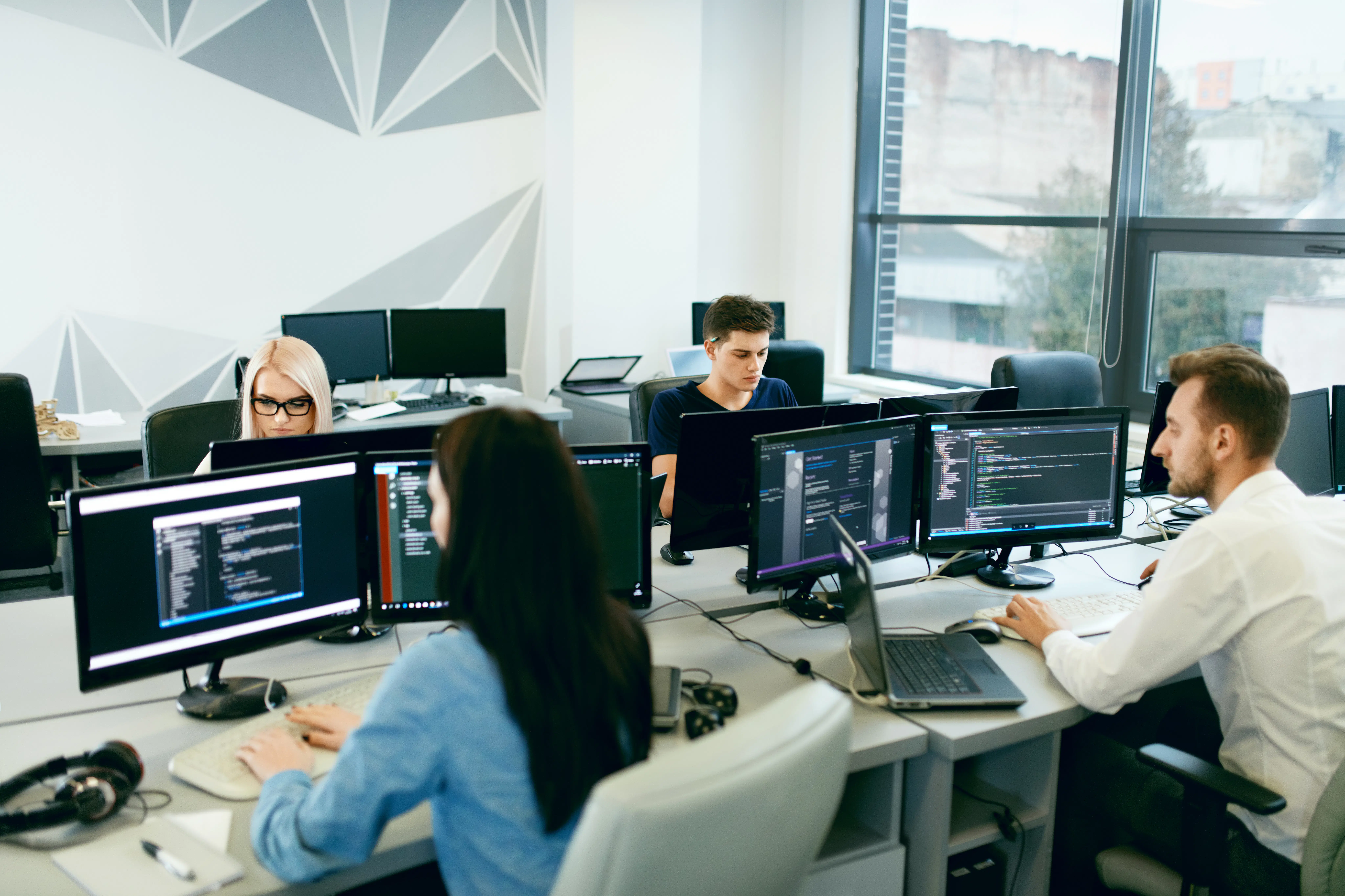 Group of young developers working on their computers in a modern office
