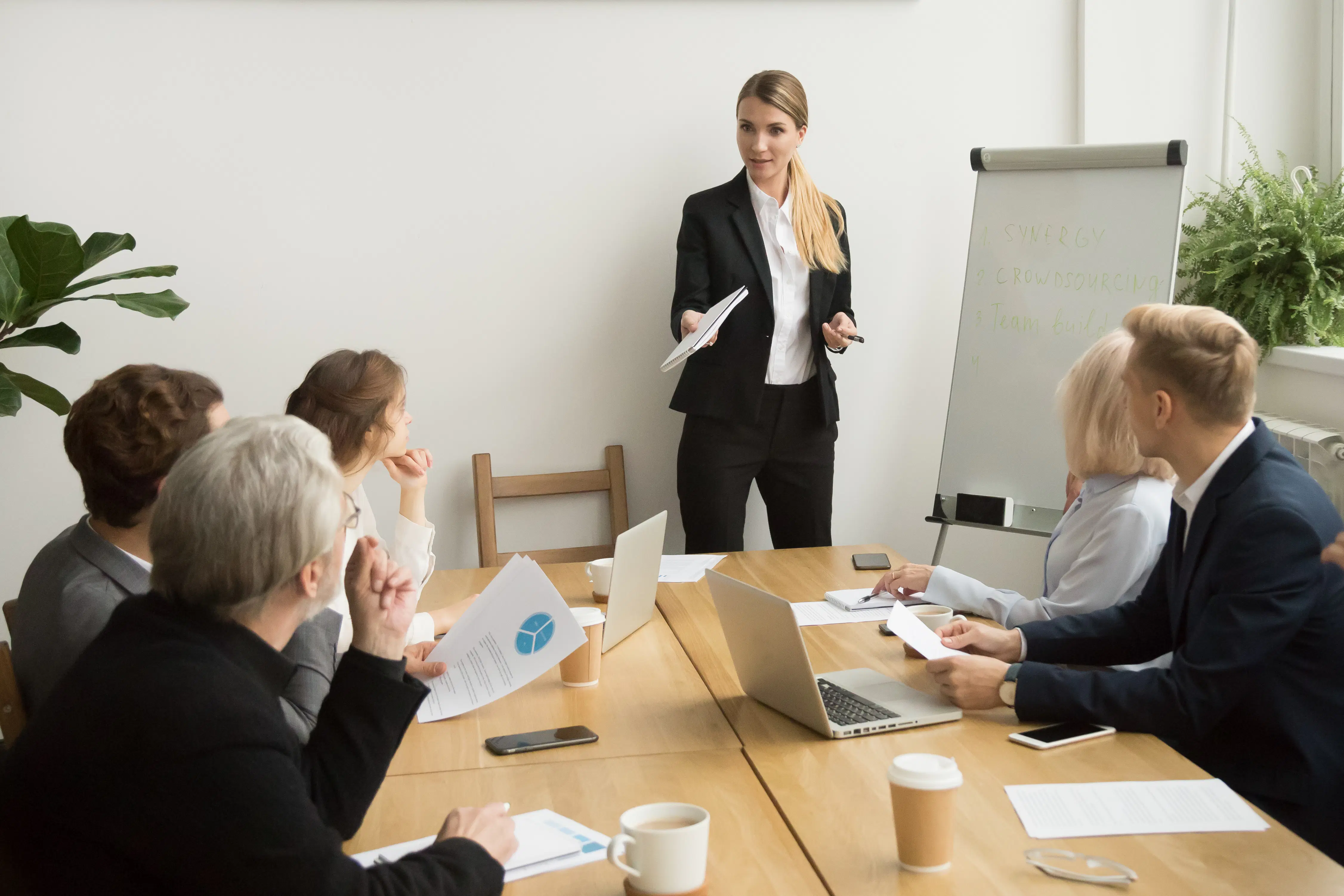Female staff member speaks in front of her colleagues during a business meeting