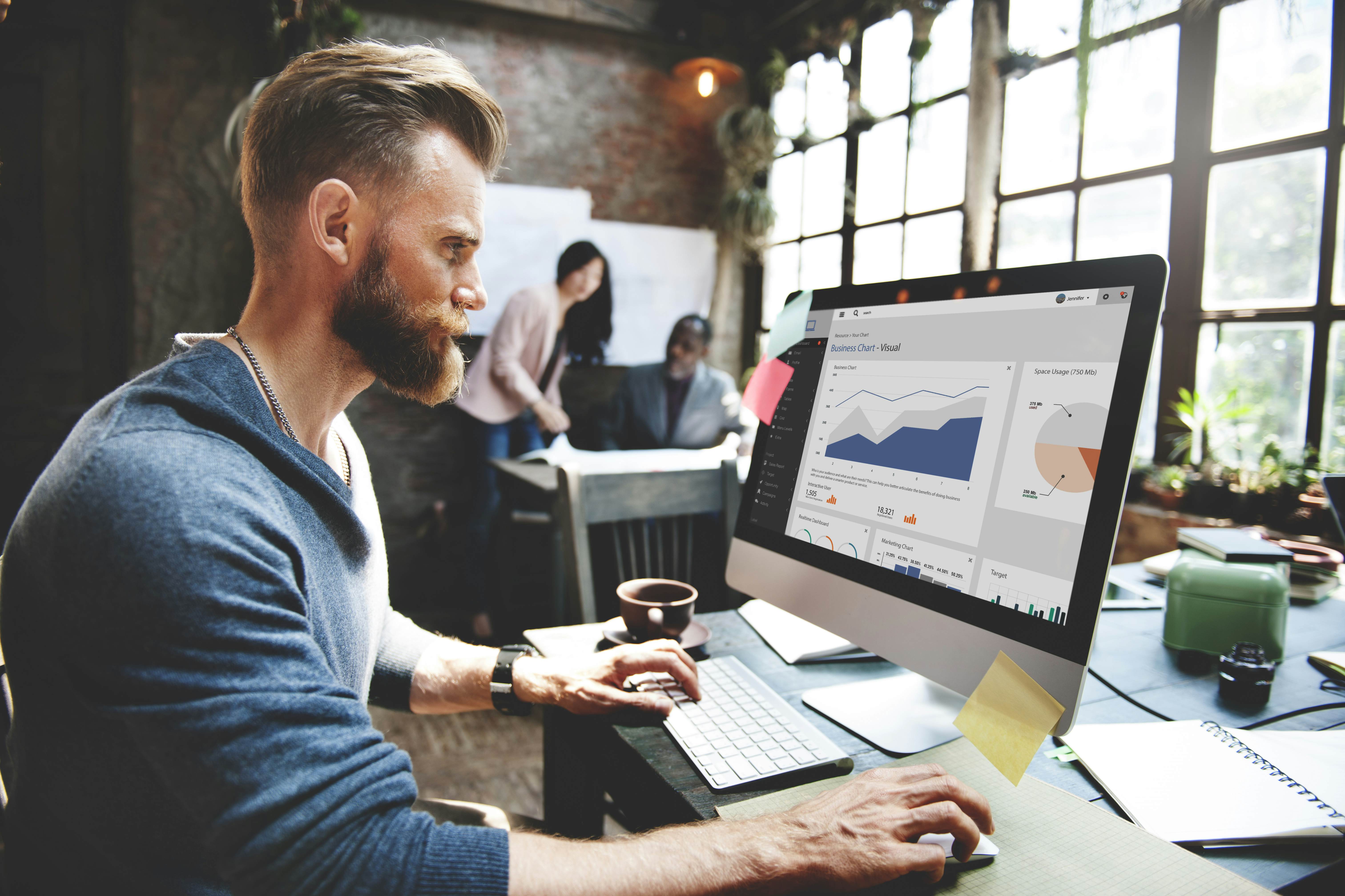 Employee analysing business graphics and reports on his computer
