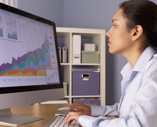 Data analyst examining information displayed on her desktop