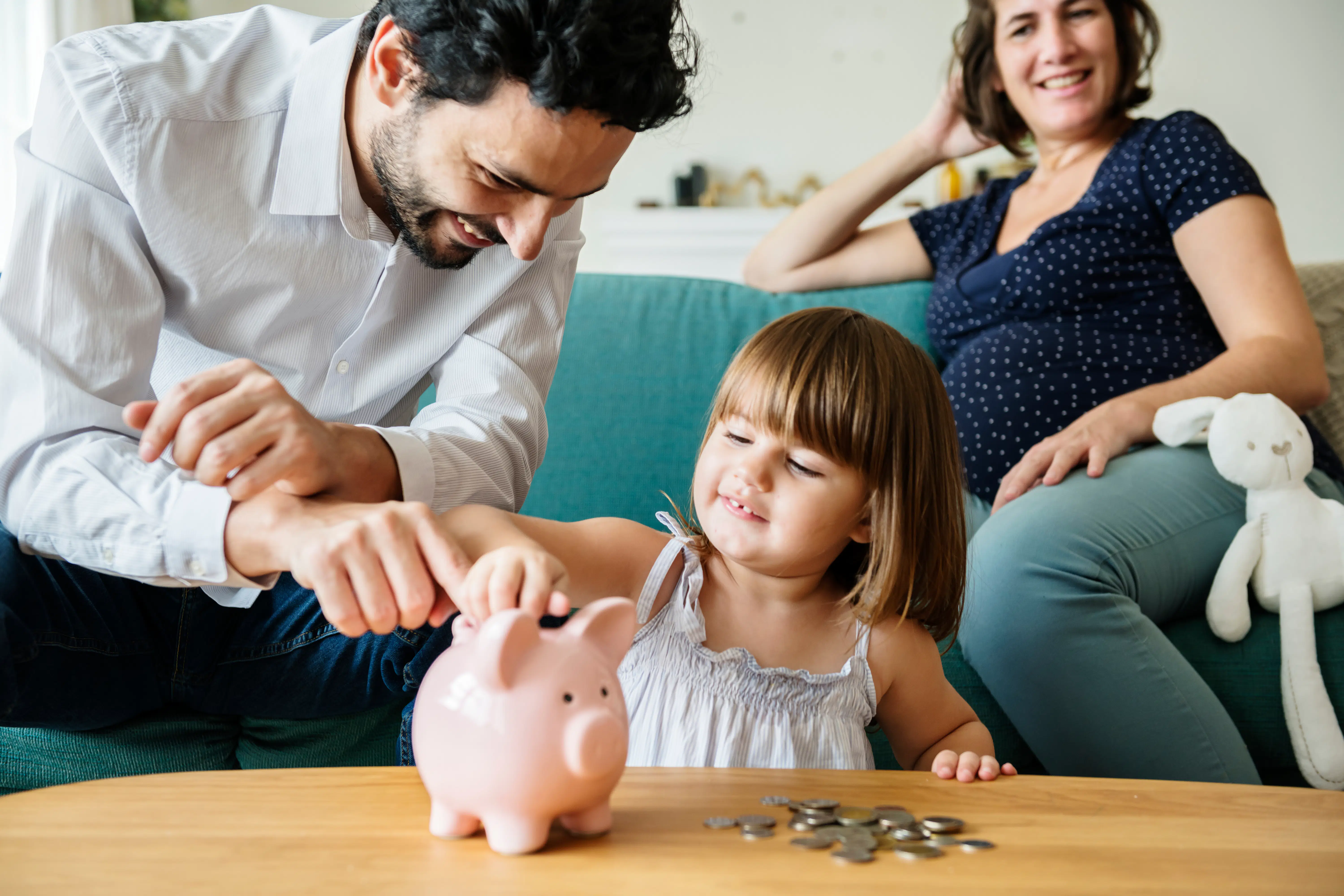 Family teaching young daughter to save money