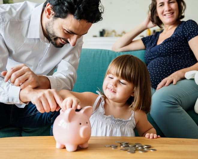 Family teaching young daughter to save money