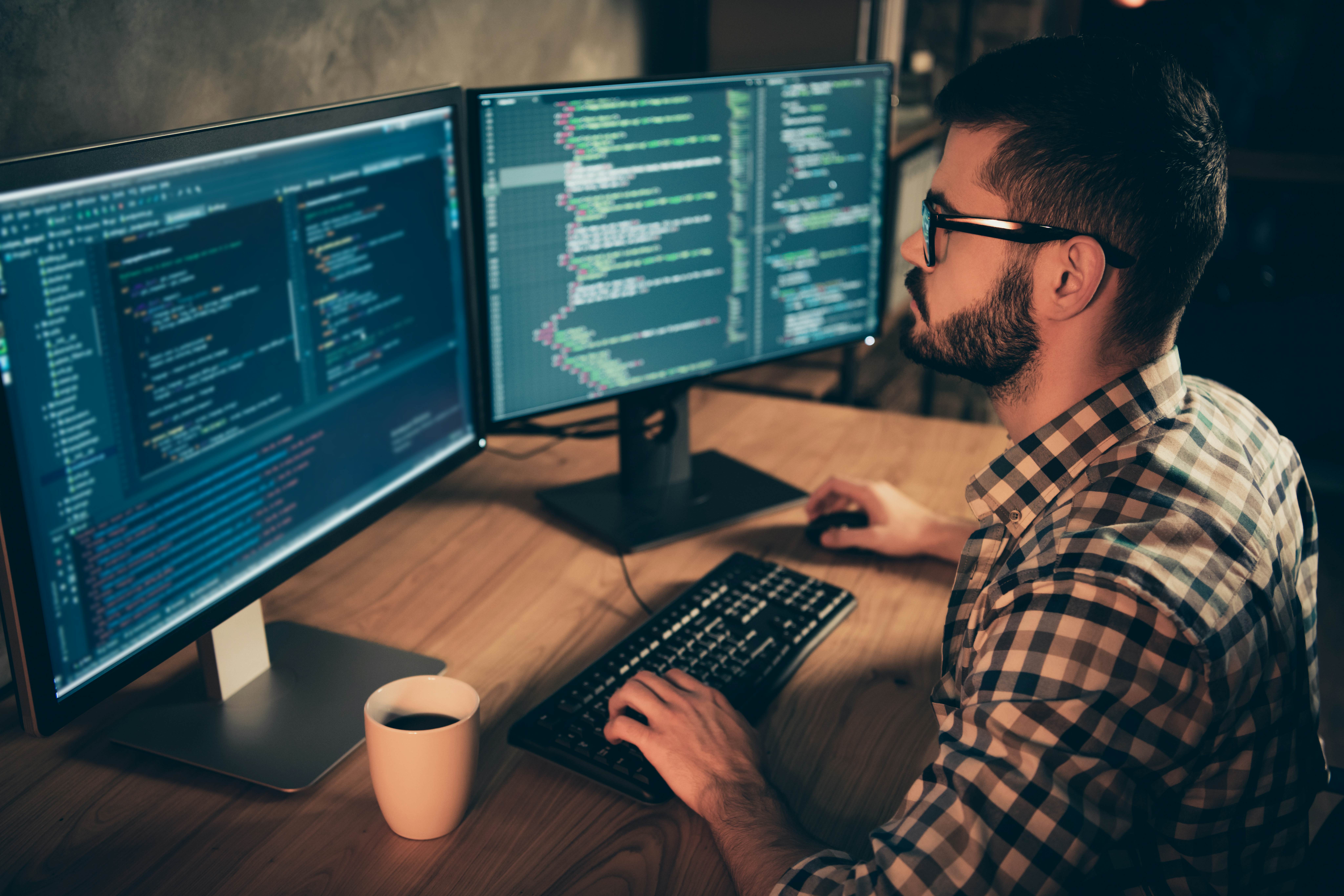 Computer programmer writing and reviewing lines of code