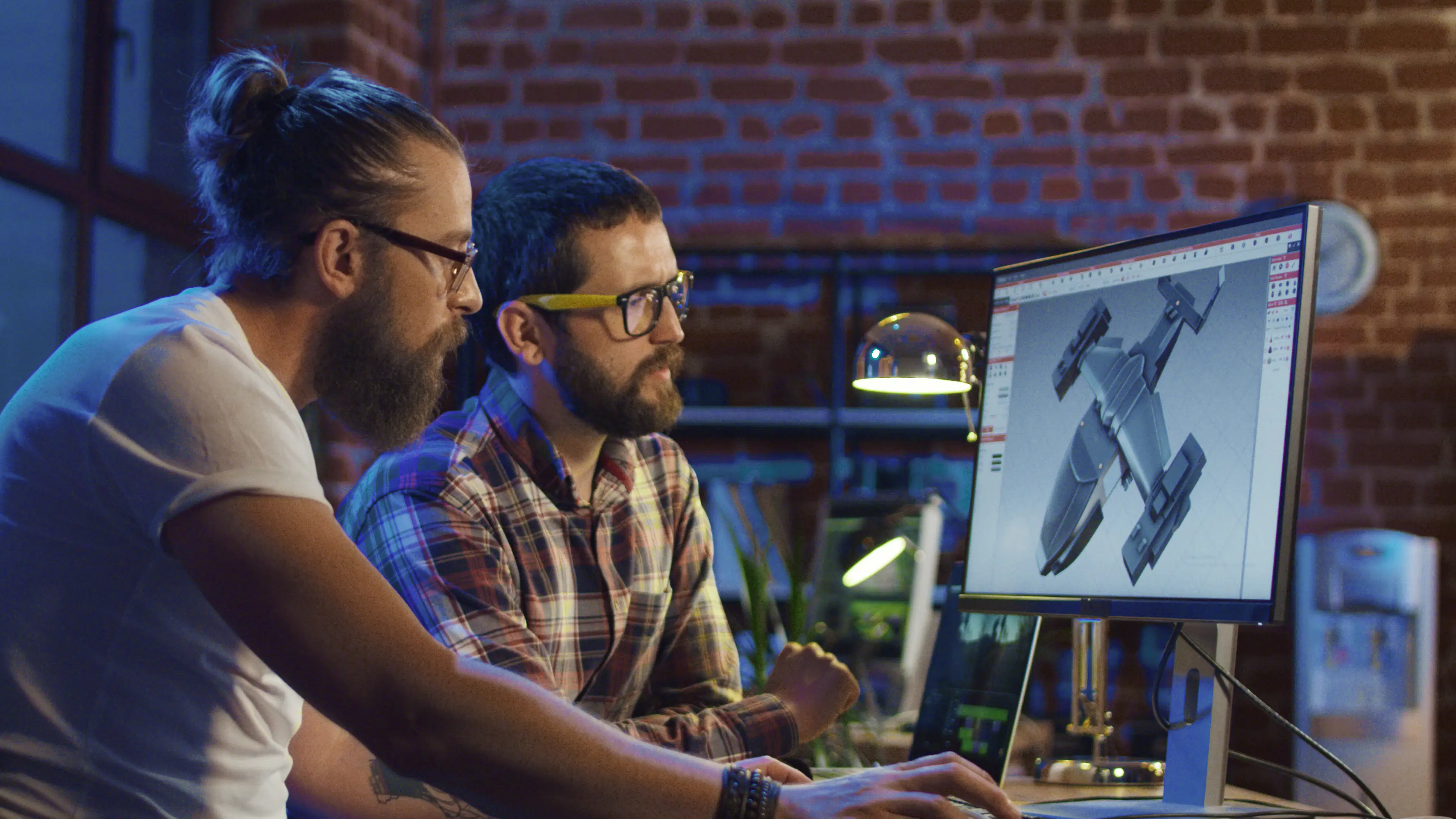 Two male industrial designers working on a model created with CAD software