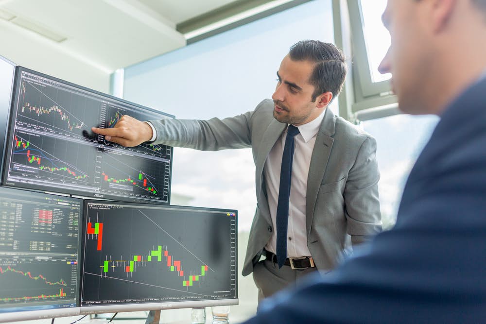 Financial analyst discussing graphs with clients